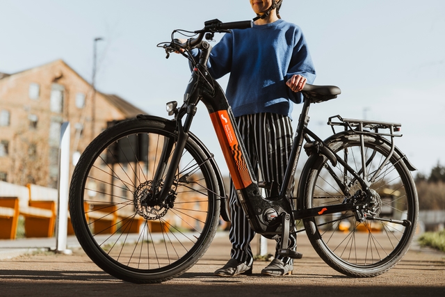 Woman standing next to bike with South Yorkshire People's Network branding.