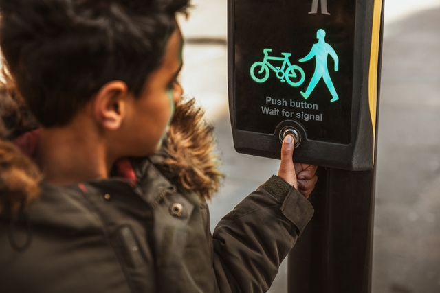Child pushing button at traffic lights