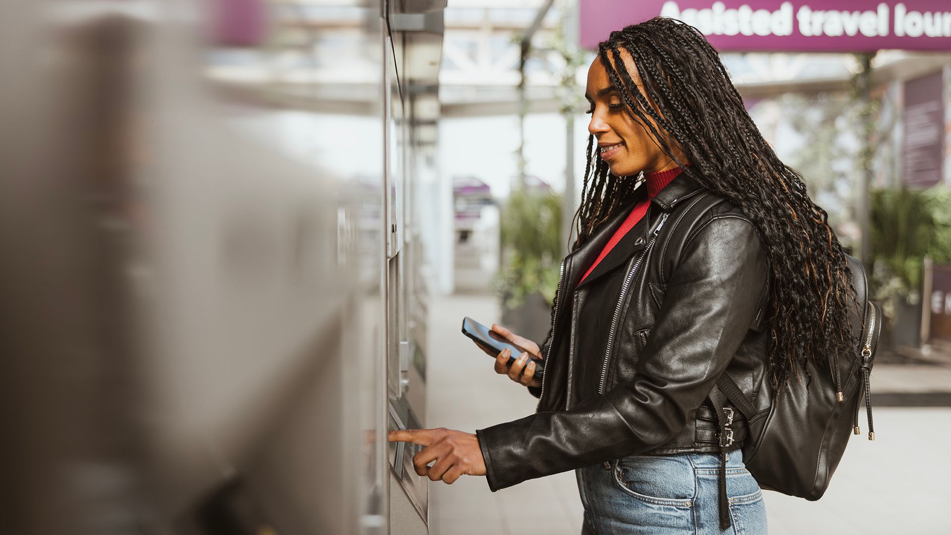 Woman paying for train tickets on machine