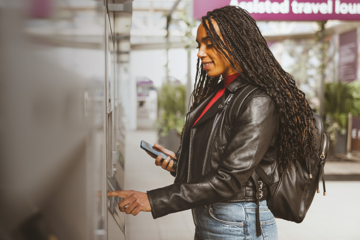 Lady buying train ticket at machine