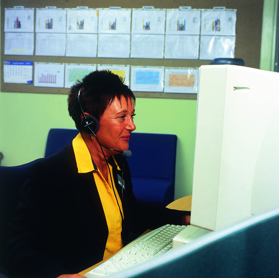 Woman at desk with computer and headset on